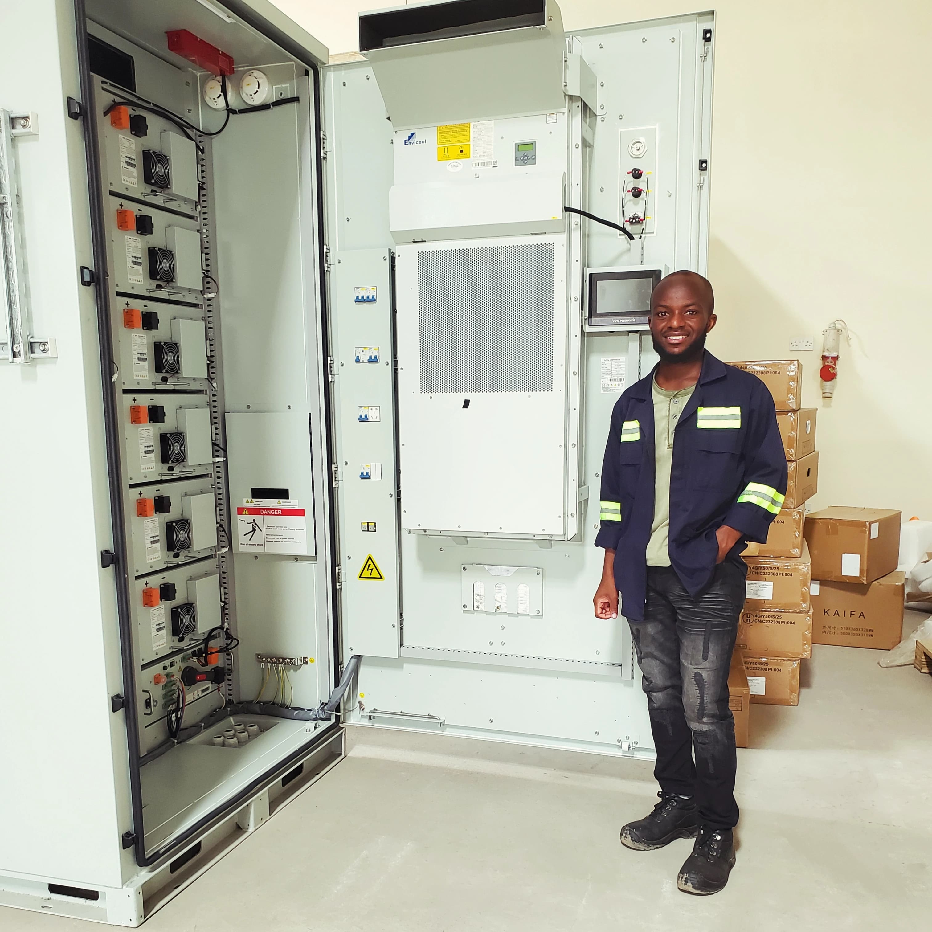 Joseph standing beside a 150kva inverter battery bank